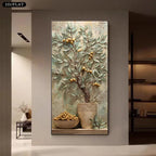 A vertical framed wall art piece showing a textured painting of a pomegranate tree with green leaves and golden pomegranates in a vase, displayed on a beige wall in a modern interior setting.