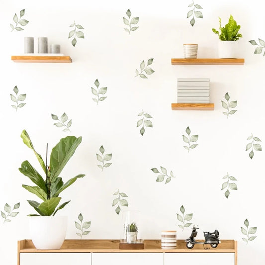 Decorative wall stickers of leaves on a white wall with shelves and plants.