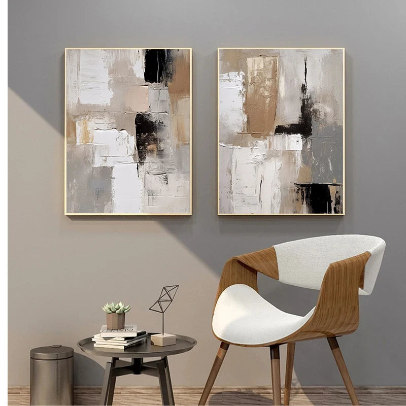 Two abstract paintings on a gray wall with a modern chair and side table.