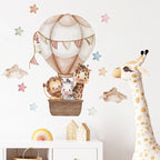 Children's room with wall decal of animals in a hot air balloon, stuffed giraffe, and decorative items.