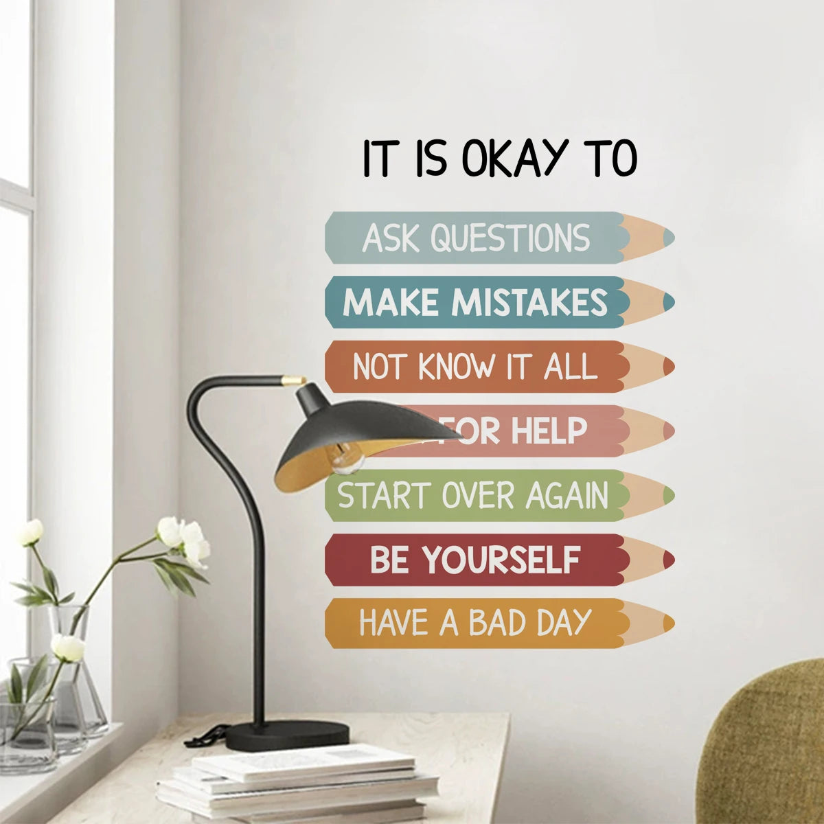 Wall decal with motivational phrases on a wall in a room with a lamp and flowers.