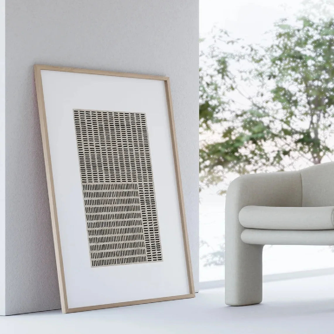 Framed abstract art piece on a wall next to a modern chair with a blurred outdoor view.