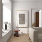 Modern interior with a framed abstract art piece on the wall, a stool, and a sofa.