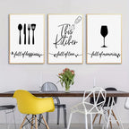 Three framed prints on a wall above a dining table with chairs.