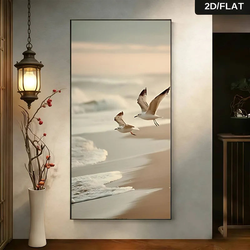Beach scene with two birds flying over sand and water, framed on a wall.