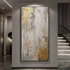 Decorative abstract painting with gold accents on a wall in a modern interior setting.
