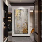 Modern interior with a large abstract painting featuring gold and gray colors.