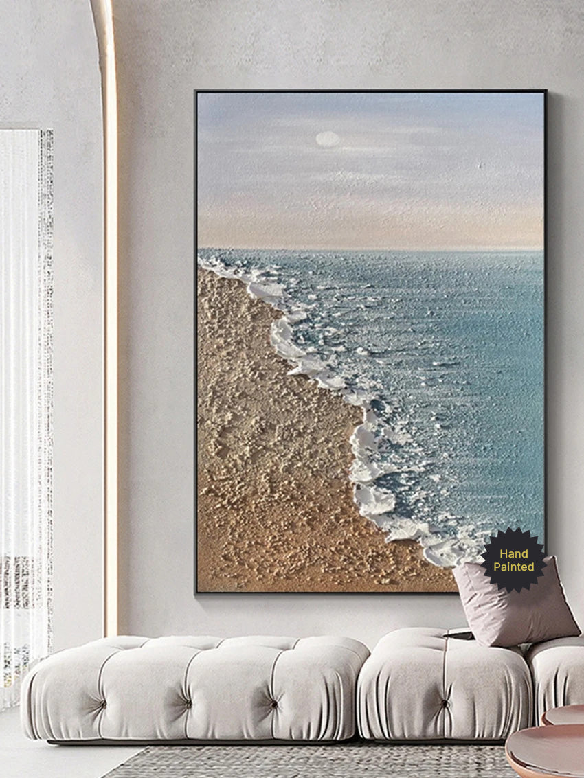 Framed beachscape painting above a sofa in a living room
