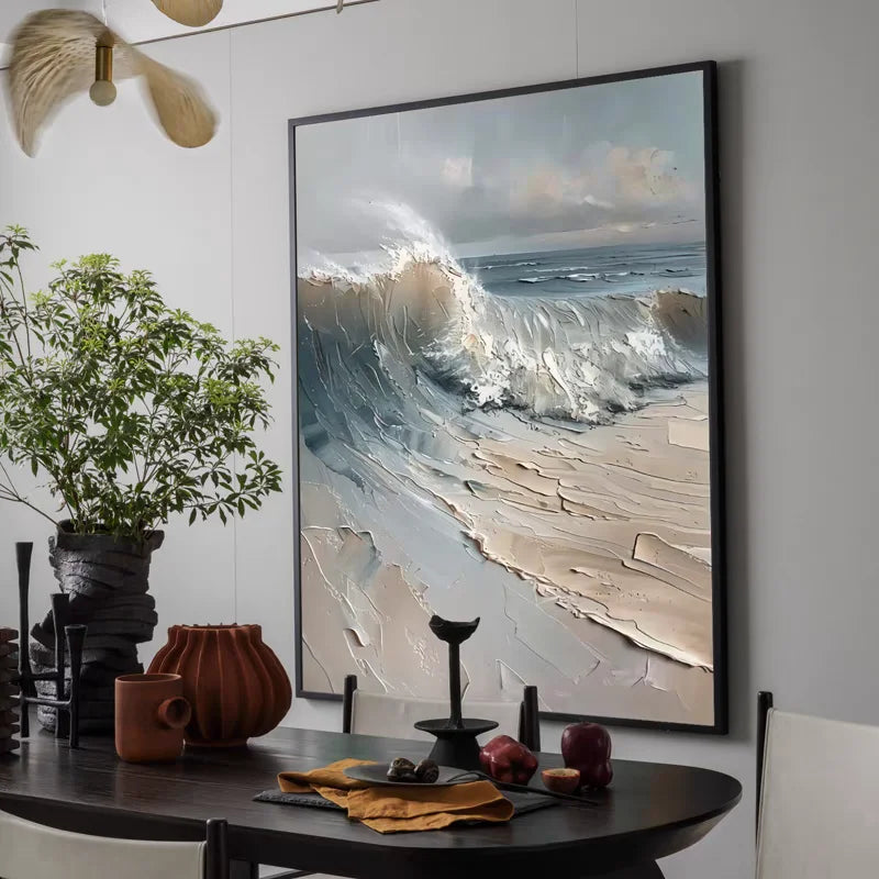 Framed artwork of a wave on a wall above a dining table with decor items.