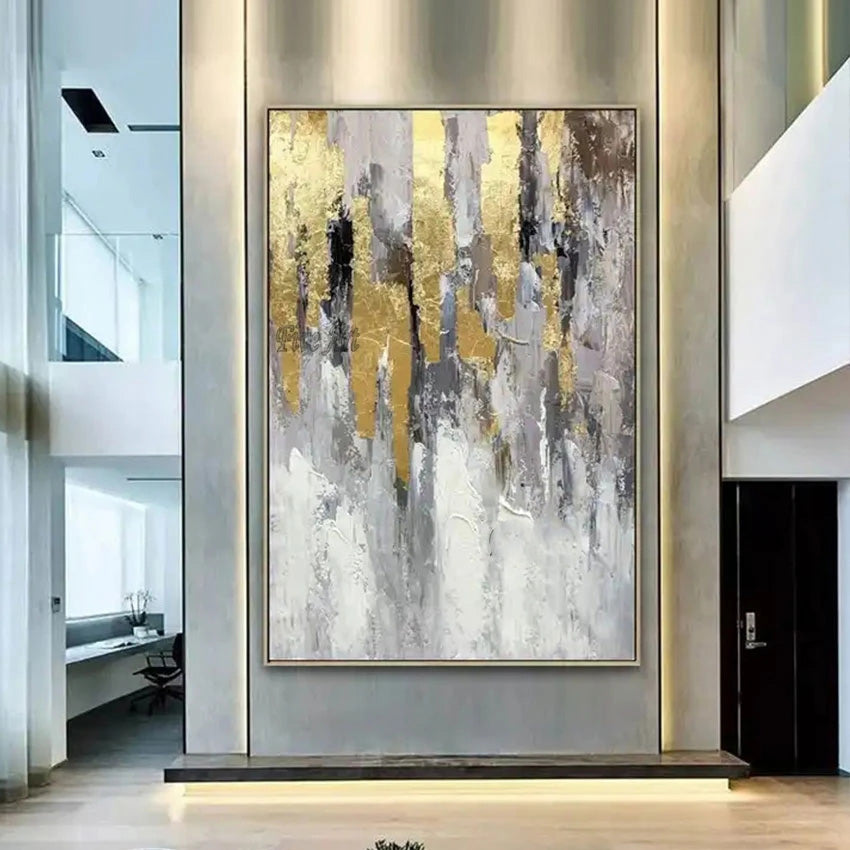 Abstract art painting with gold and gray tones in a modern interior setting.