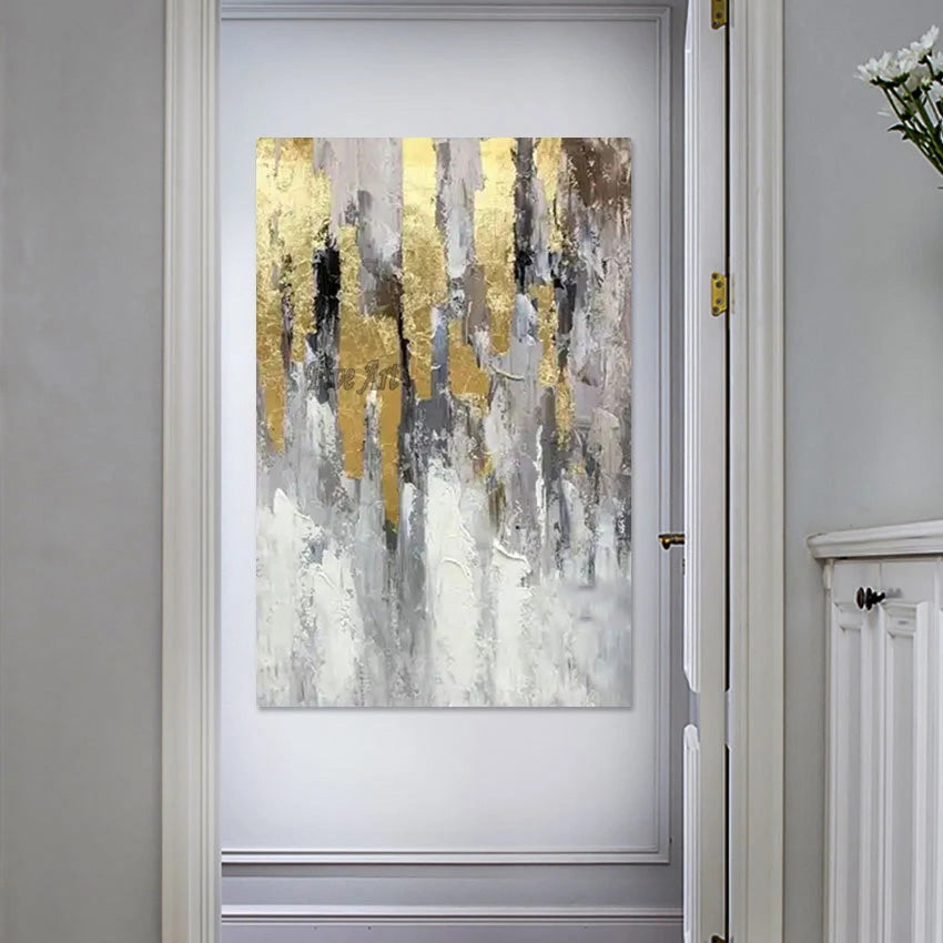 Abstract art painting with gold and gray tones on a wall in a room.