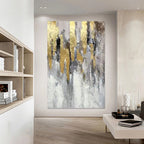 Abstract art piece with gold and gray tones in a modern living room setting.
