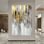 Abstract art painting with gold and gray tones in a modern interior setting.