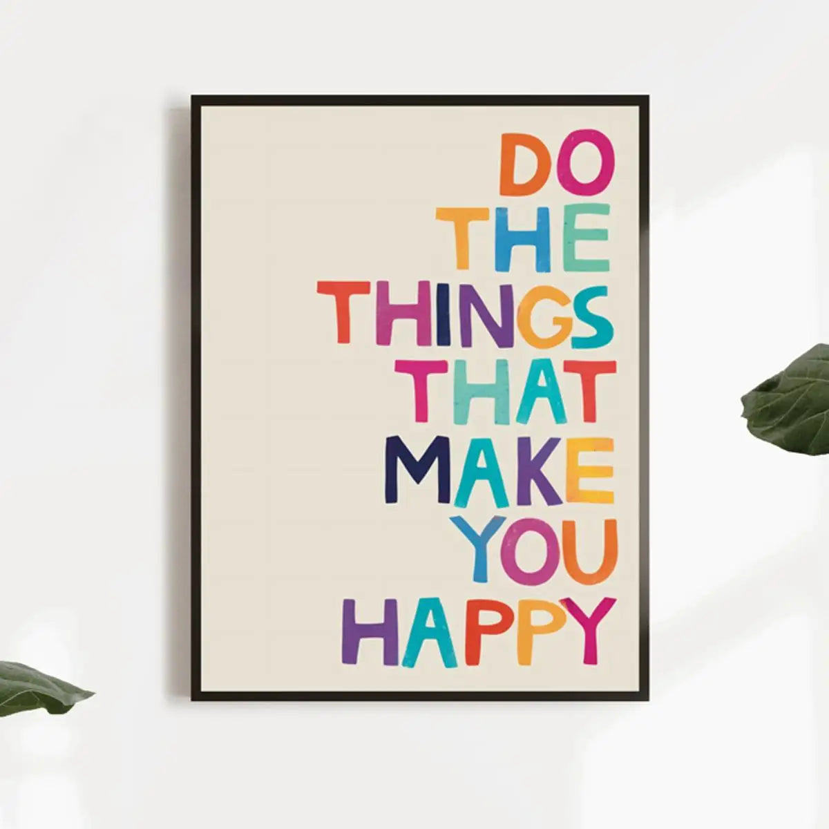 Framed poster with motivational quote 'Do the things that make you happy' in colorful letters on a white wall.