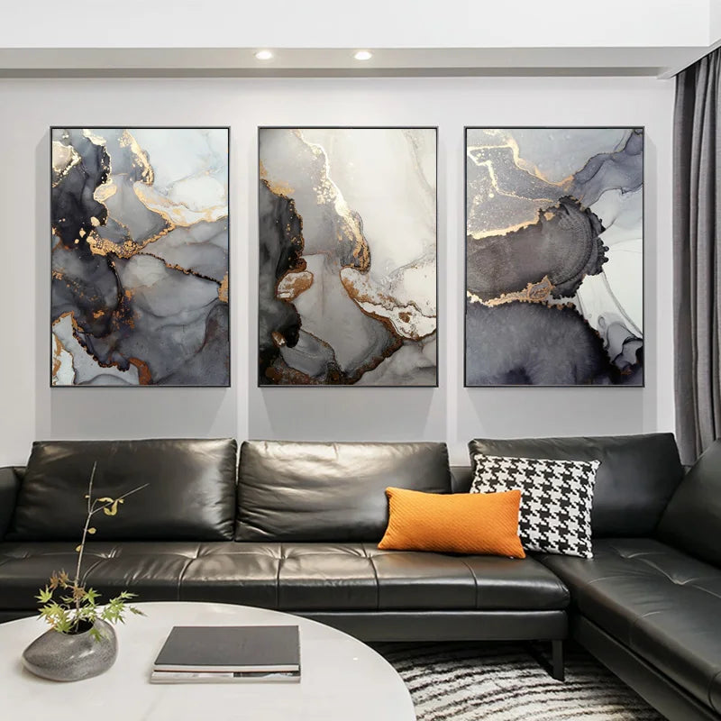 Modern living room with a black leather sofa, abstract art on the wall, and decorative pillows.