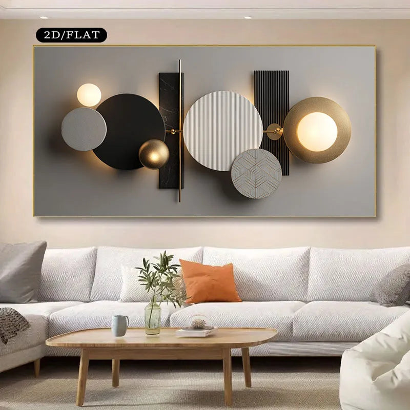 Modern abstract wall art with overlapping circles and rectangular forms in black, white, gray, and gold, shown mounted above a light sofa in a living room setting. 