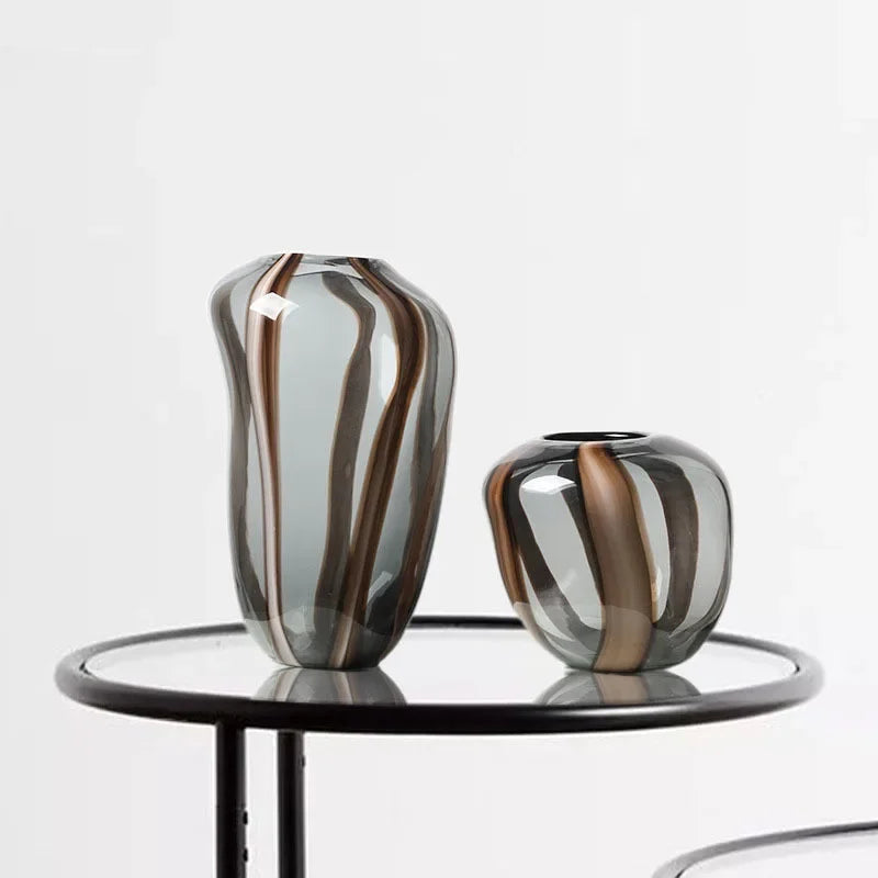 Two striped vases on a round table with a white background