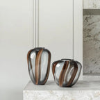 Two decorative vases with brown and clear design on a marble surface.