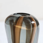Smoky glass vase with brown swirls on a white background