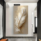 Decorative wall art of a feather with gold accents on a beige background in a modern interior setting.
