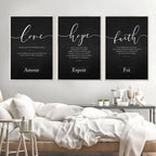 Three framed prints with motivational phrases on a wall above a bed.