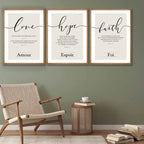 Three framed prints on a wall with 'love', 'hope', and 'faith' text, accompanied by a chair and side table.