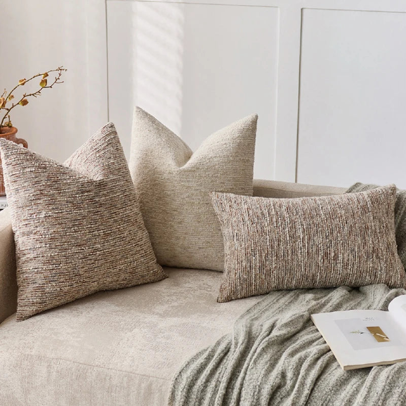 Beige textured pillows on a sofa with a neutral background