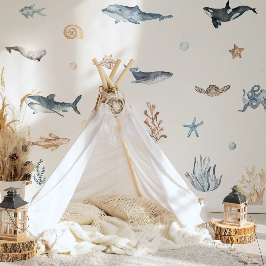 Children's play area with a teepee, lanterns, and decorative elements against a wall with whale and starfish patterns.