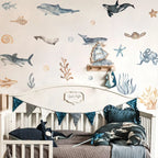 Nursery room with ocean-themed wall decals and bedding.