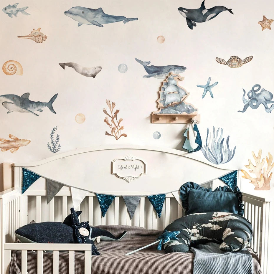 Nursery room with ocean-themed wall decals and bedding.
