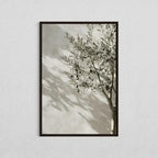 Framed artwork of a leafy branch against a neutral background