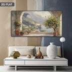 A horizontal landscape canvas print depicting a scenic Italian coastal town with lemon trees and mountains, displayed on a wall above a modern white sofa in a styled living room.