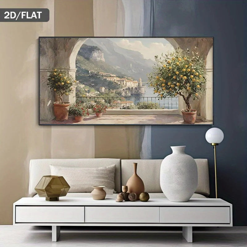 A horizontal landscape canvas print depicting a scenic Italian coastal town with lemon trees and mountains, displayed on a wall above a modern white sofa in a styled living room.