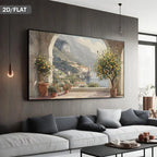 A large framed wall art print showing a scenic coastal village with lemon trees and mountains, displayed above a modern white sofa in a contemporary living room. The text '2D/FLAT' appears in the top-left corner.