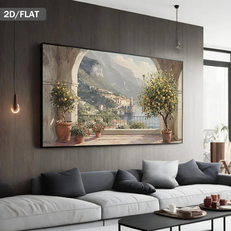 A large framed wall art print showing a scenic coastal village with lemon trees and mountains, displayed above a modern white sofa in a contemporary living room. The text '2D/FLAT' appears in the top-left corner.