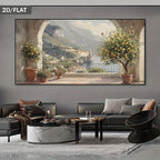 A large framed wall art print showing a scenic coastal town with mountains, water, and lemon trees, displayed above a modern gray sofa in a styled living room. The print has a dark gray border and the words '2D/FLAT' appear in the top-left corner.