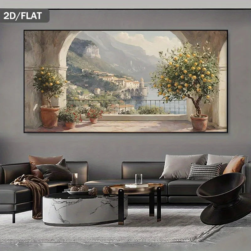 A large framed wall art print showing a scenic coastal town with mountains, water, and lemon trees, displayed above a modern gray sofa in a styled living room. The print has a dark gray border and the words '2D/FLAT' appear in the top-left corner.