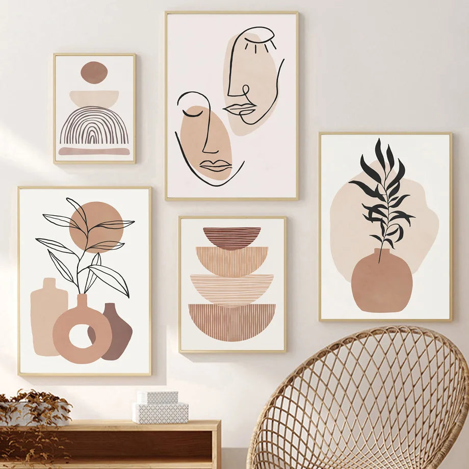 Set of abstract art prints in neutral colors on a wall with a wicker chair.