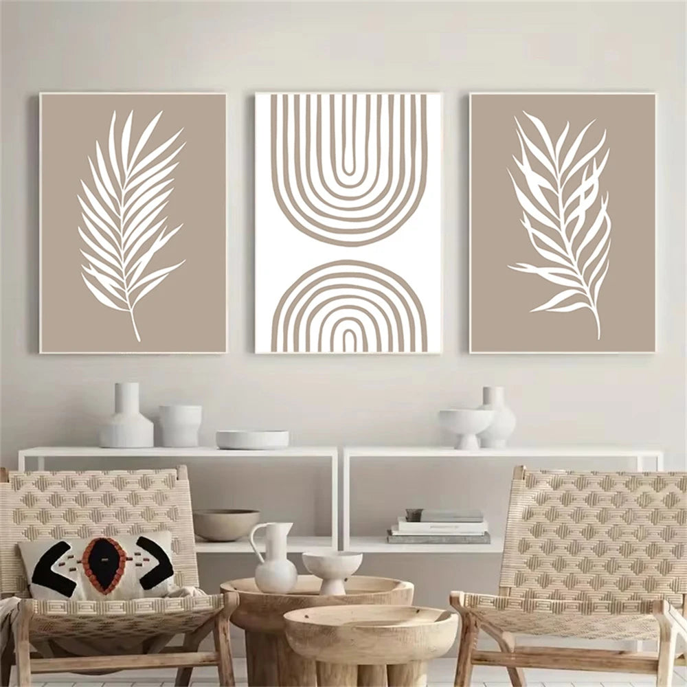 Three abstract wall art prints on a neutral wall with chairs and decor below.