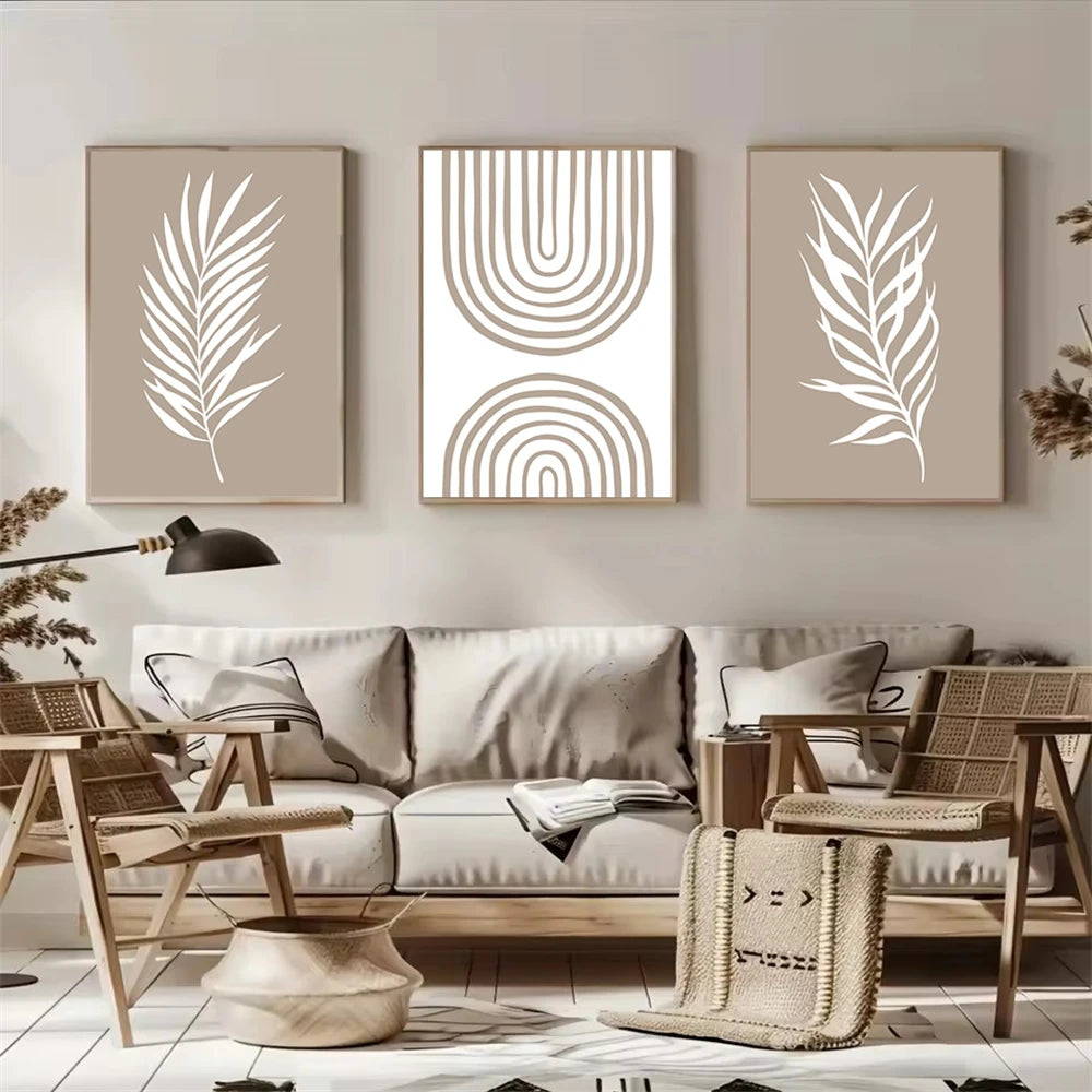 Living room with a beige sofa, wicker chairs, and wall art featuring leaf and geometric designs.