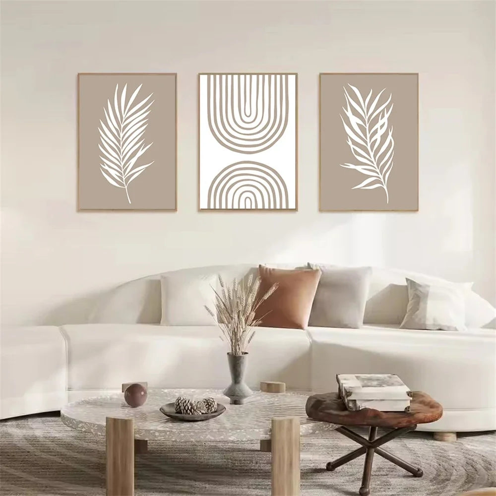 Living room with a white sofa, wooden coffee table, and wall art featuring leaf and geometric designs.