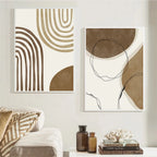 Two abstract art pieces in brown and beige tones on a wall above a sofa.