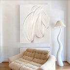 Beige sofa in a room with a large abstract painting and a tall white lamp.