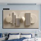 Abstract wall art piece on a light blue wall above a bed with blue and white bedding.