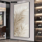 A large vertical framed wall art piece featuring a stylized beige palm leaf on a white background, displayed in a modern interior hallway with shelving and a doorway visible.