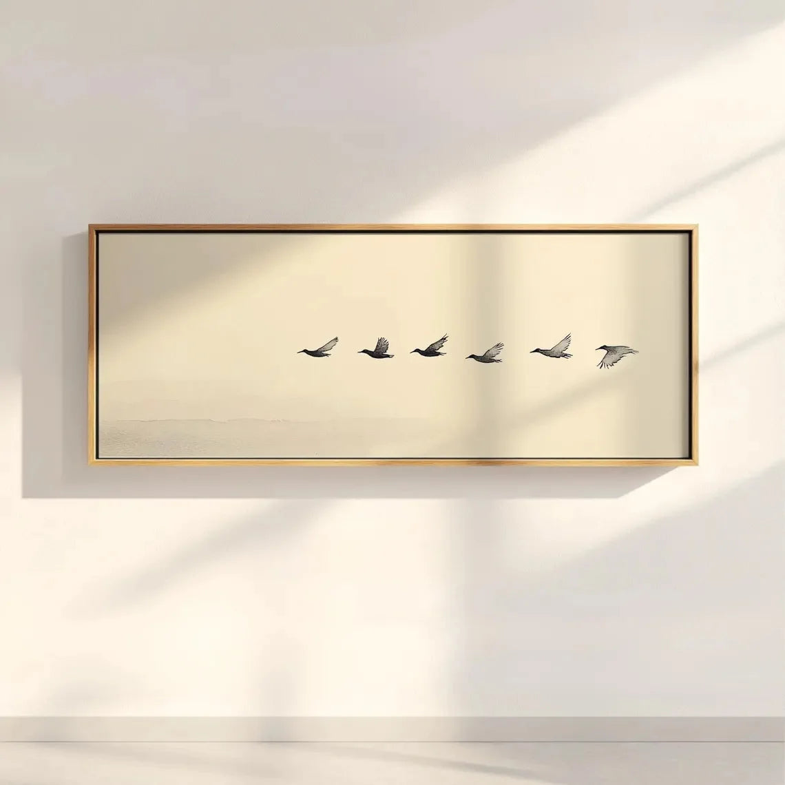 Framed artwork of five birds on a beige background, mounted on a wall.