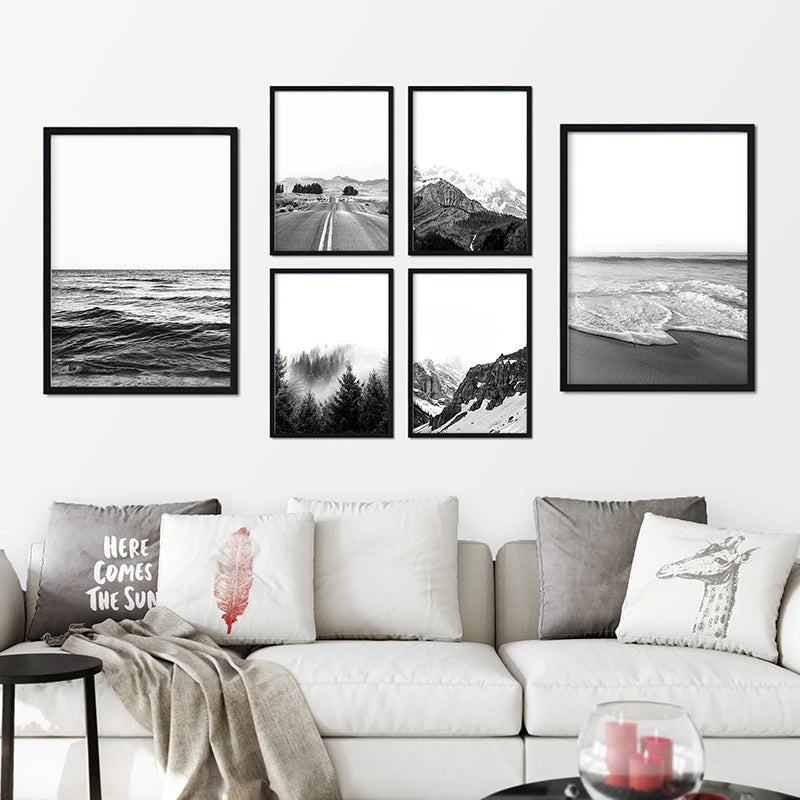 Set of framed black and white landscape photos on a wall above a sofa.