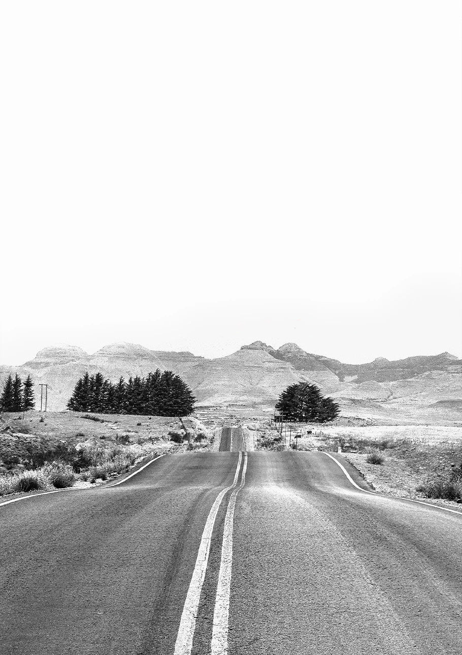Long straight road stretching into the distance with mountains in the background