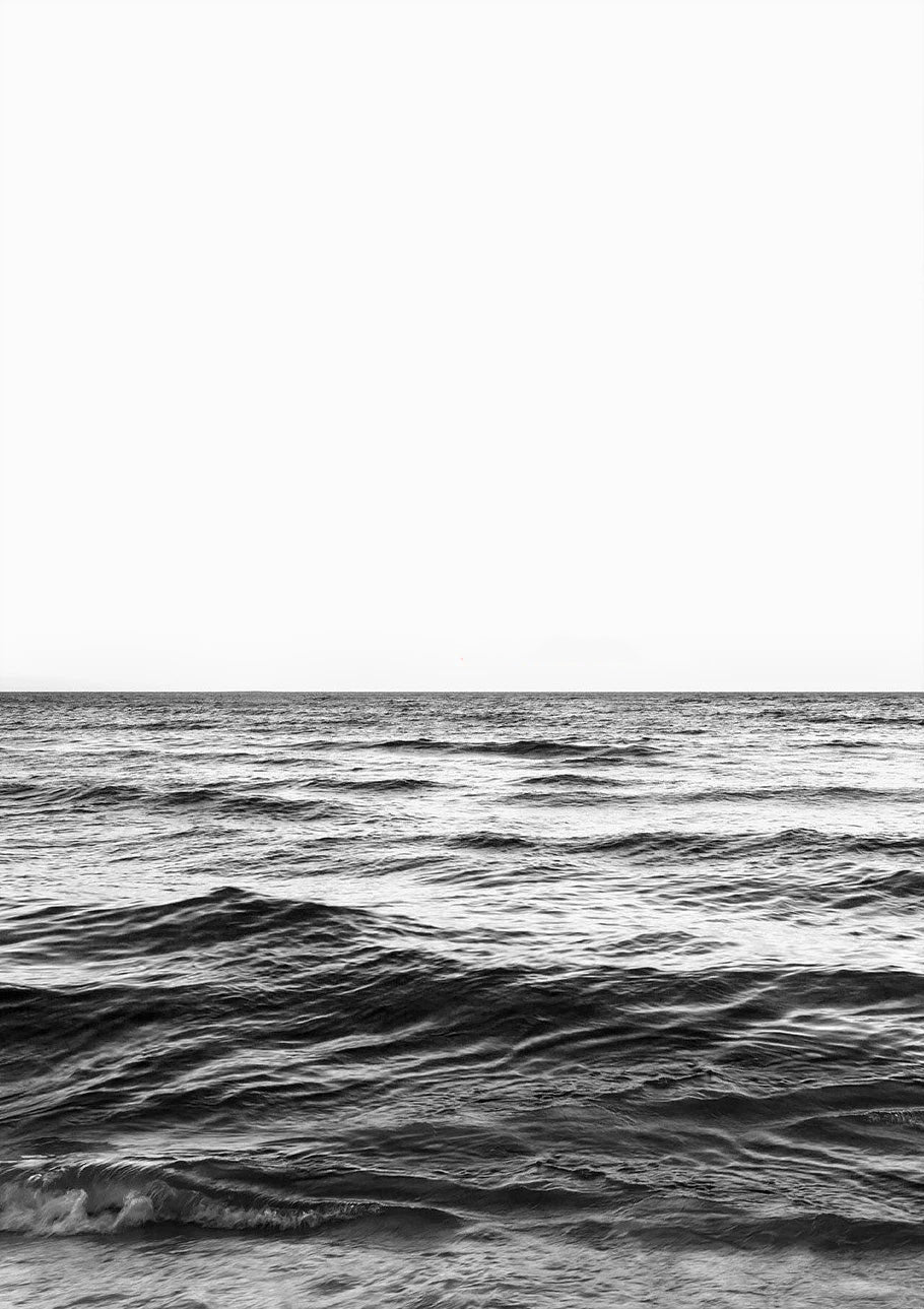 Black and white photo of ocean waves with a clear horizon line.