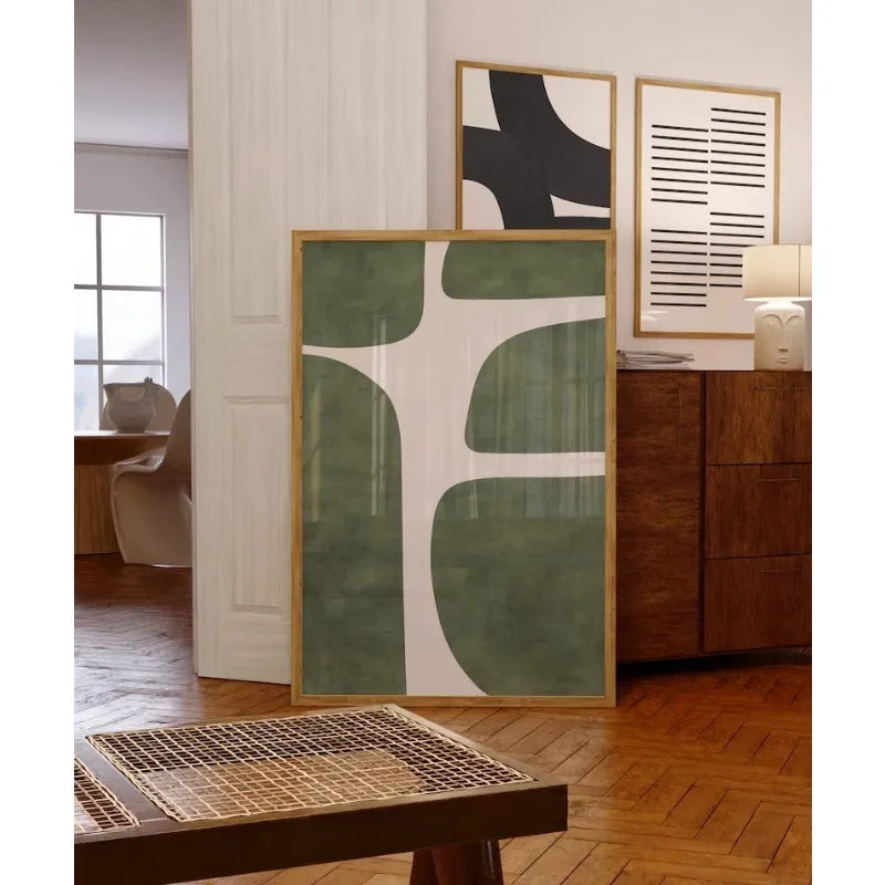 Modern abstract art pieces on a wall in a stylish room with wooden furniture.